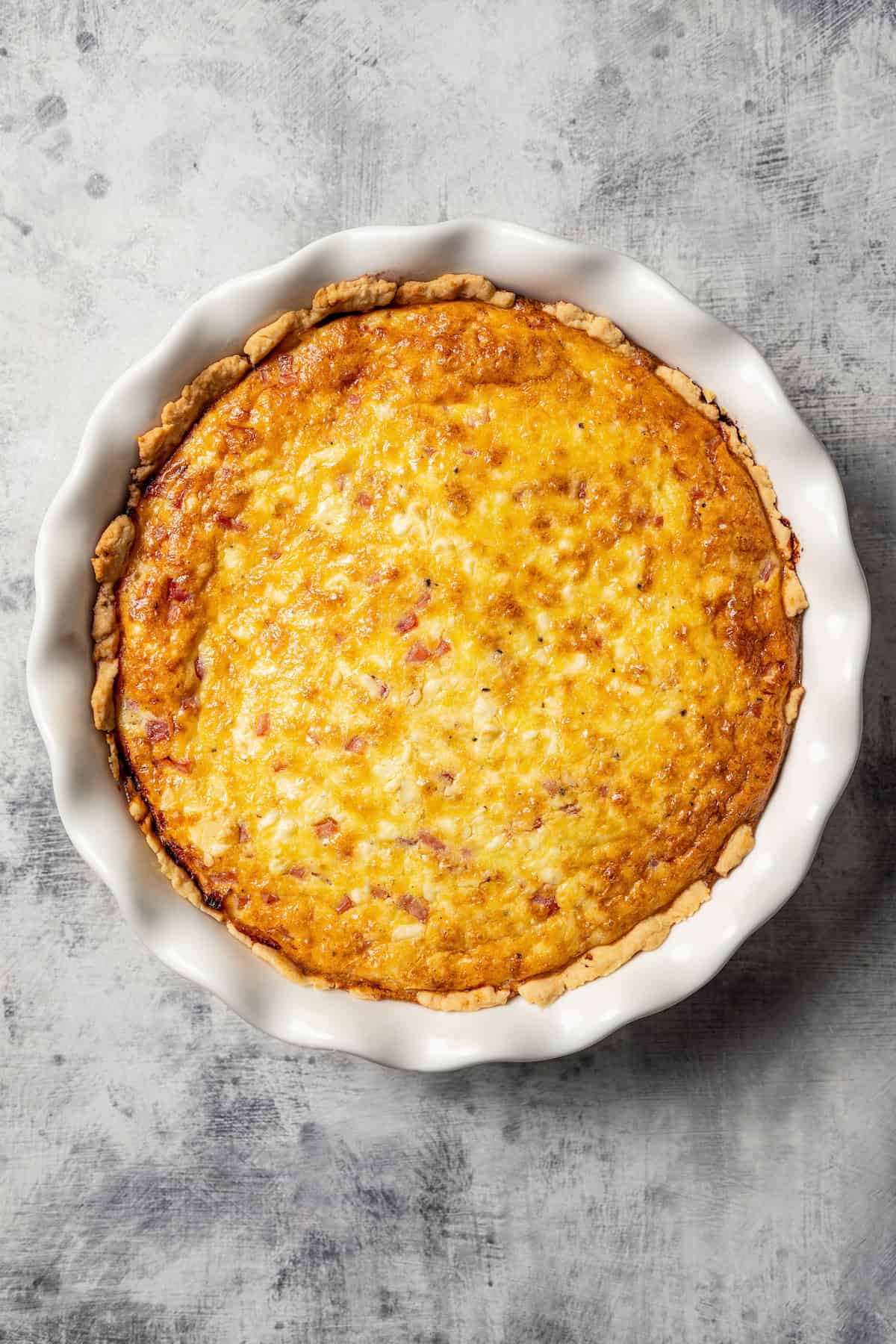 Baked ham and cheese quiche in a pie plate.