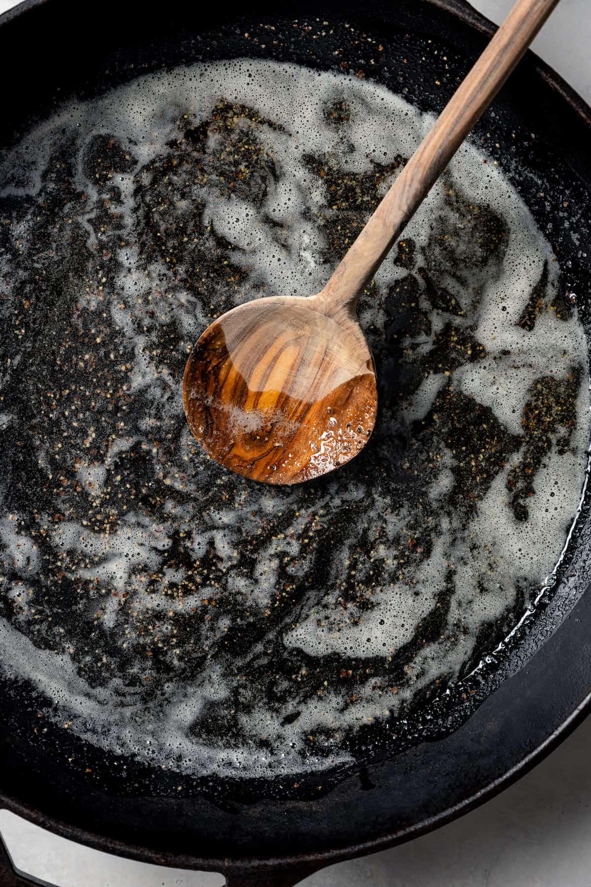 Melted butter in a skillet with a wooden spoon.