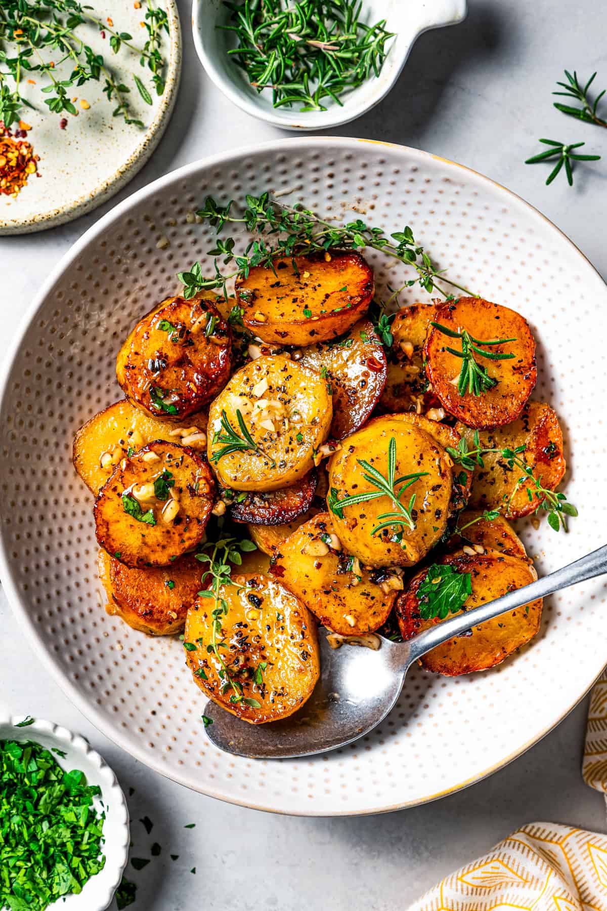 Overhead view of melting potatoes in a large bowl with a serving spoon.