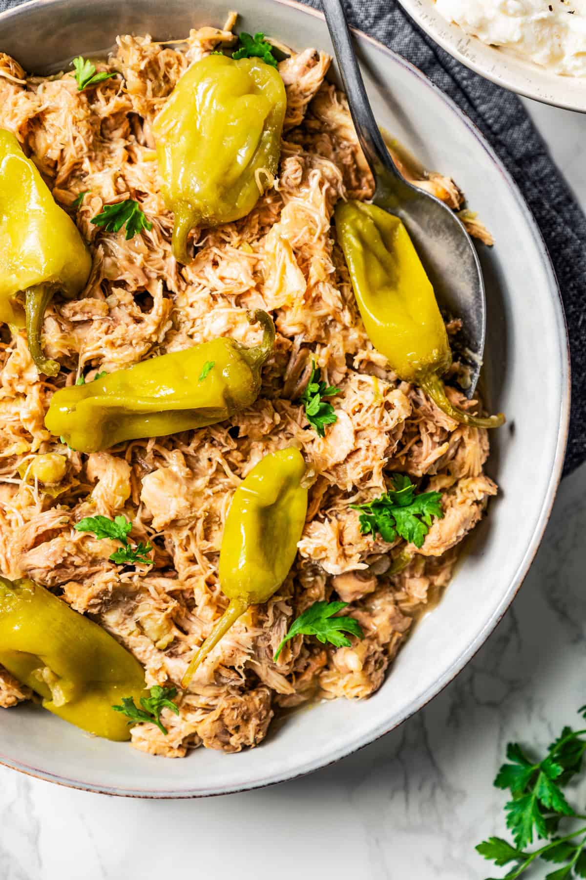 Shredded Mississippi chicken and pepperoncini in a bowl.