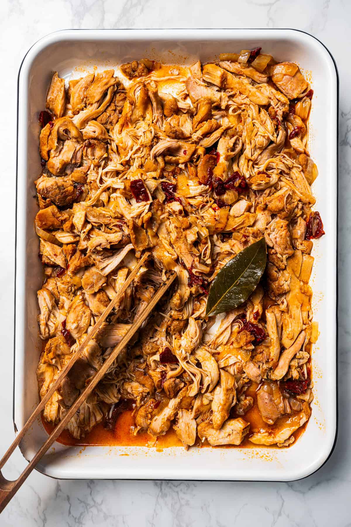 Shredded chicken tinga in a baking dish.