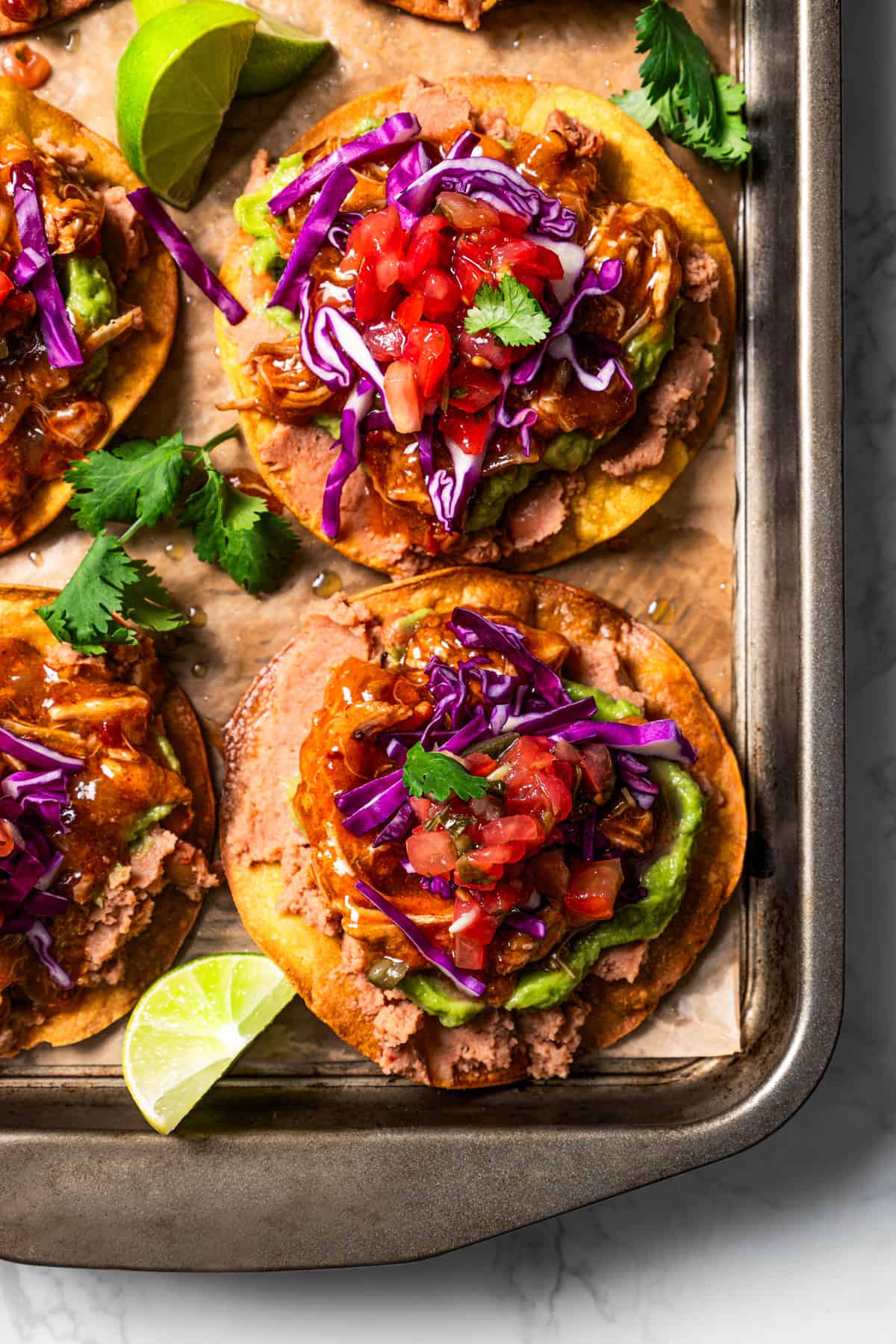 Assembled tostadas set on a baking sheet.