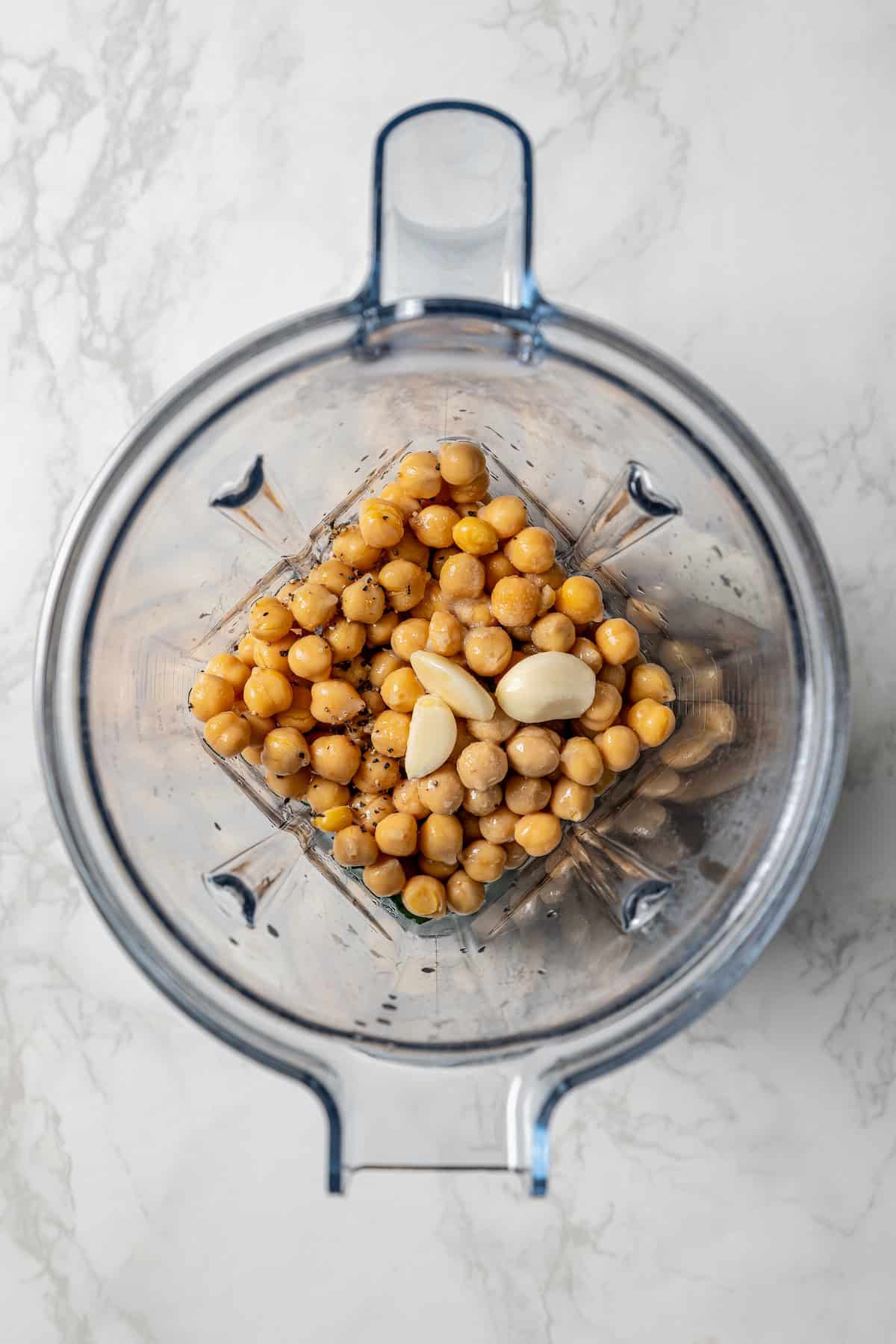 Chickpeas and garlic added to a blender.