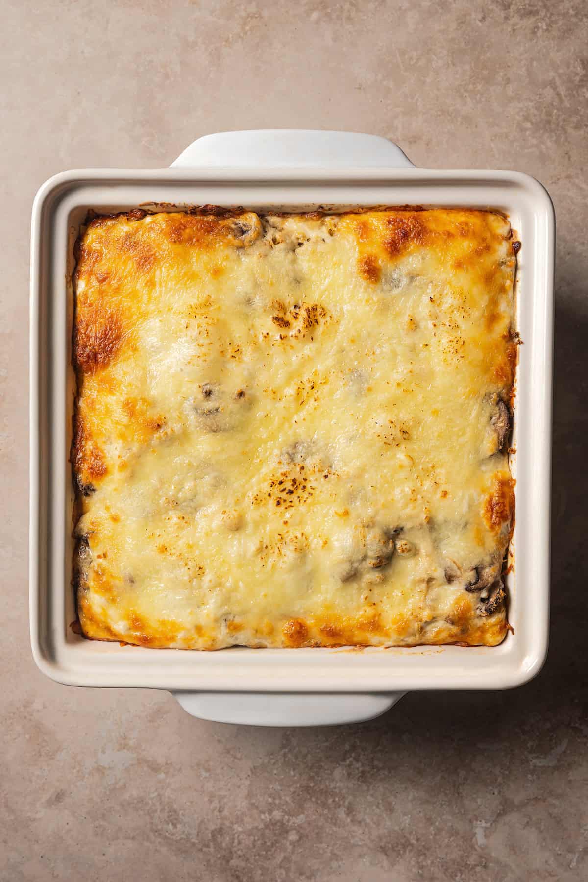 Baked white chicken lasagna in a ceramic baking dish.