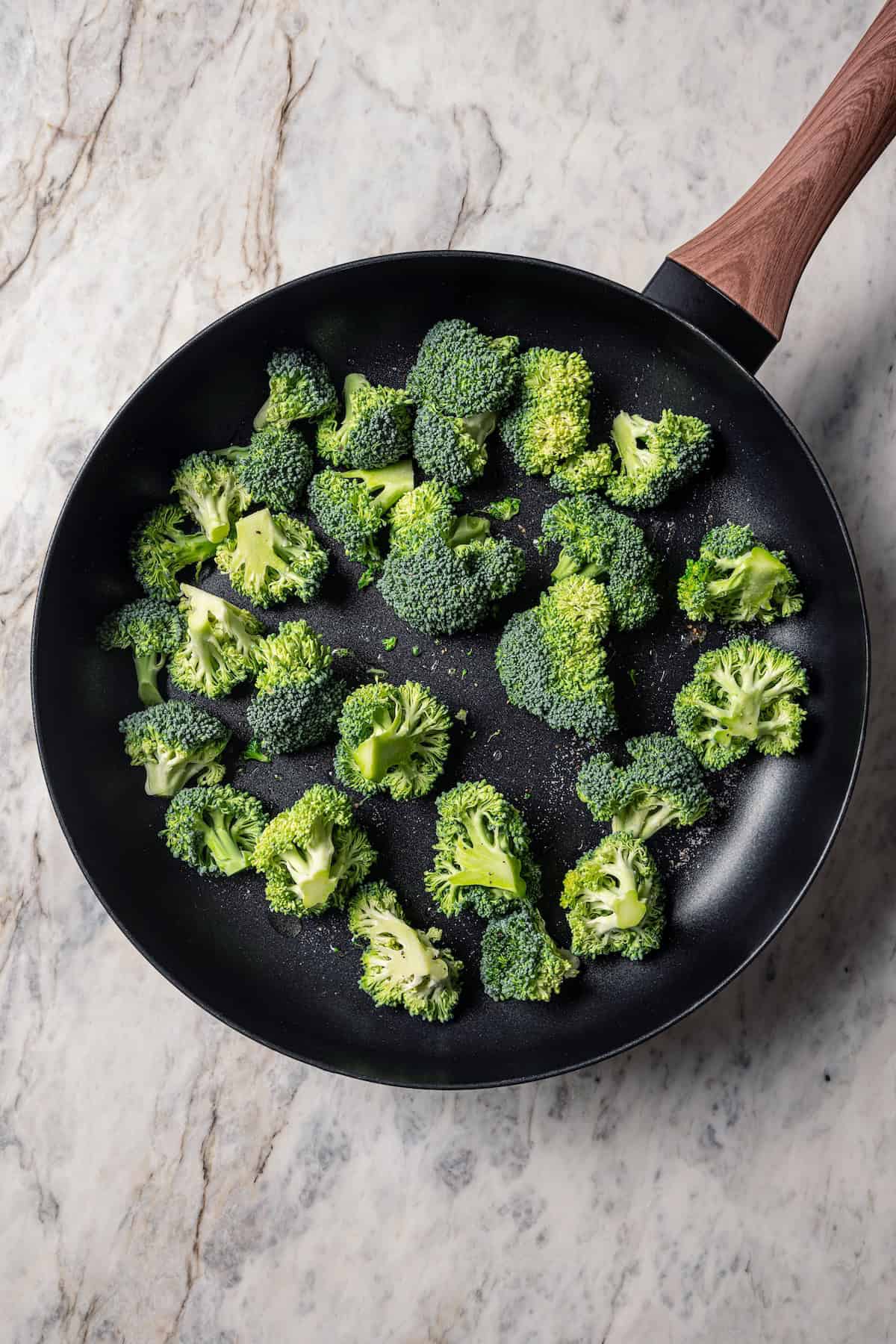 Broccoli florets in a skillet.