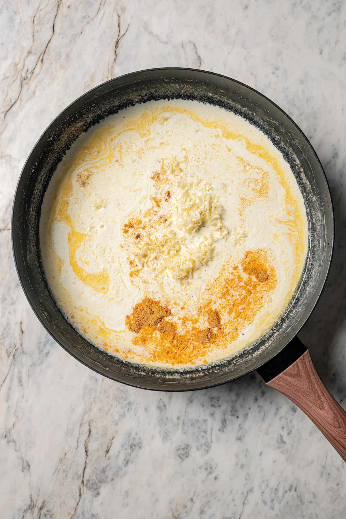 Alfredo sauce ingredients combined in a skillet.