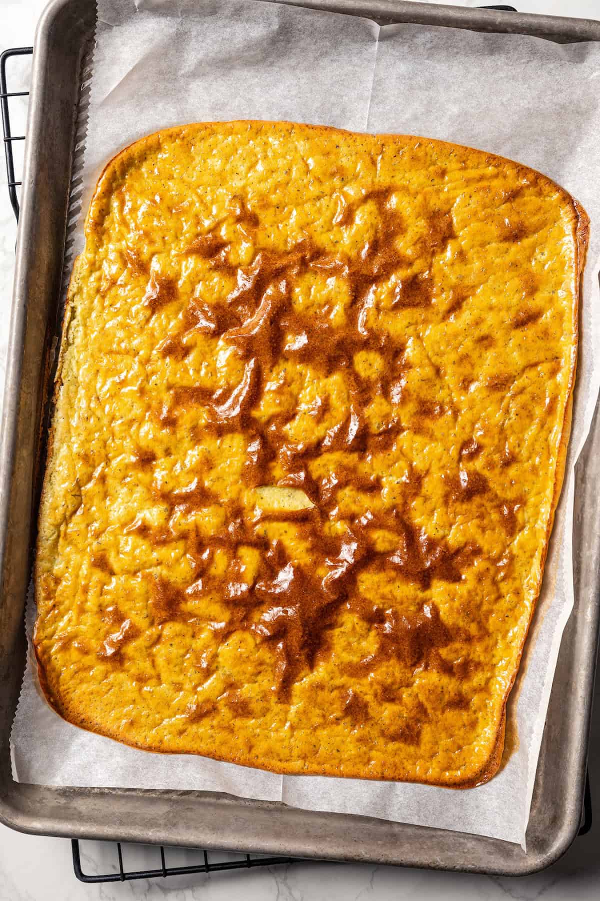 Baked cottage cheese flatbread on a parchment-lined baking sheet.