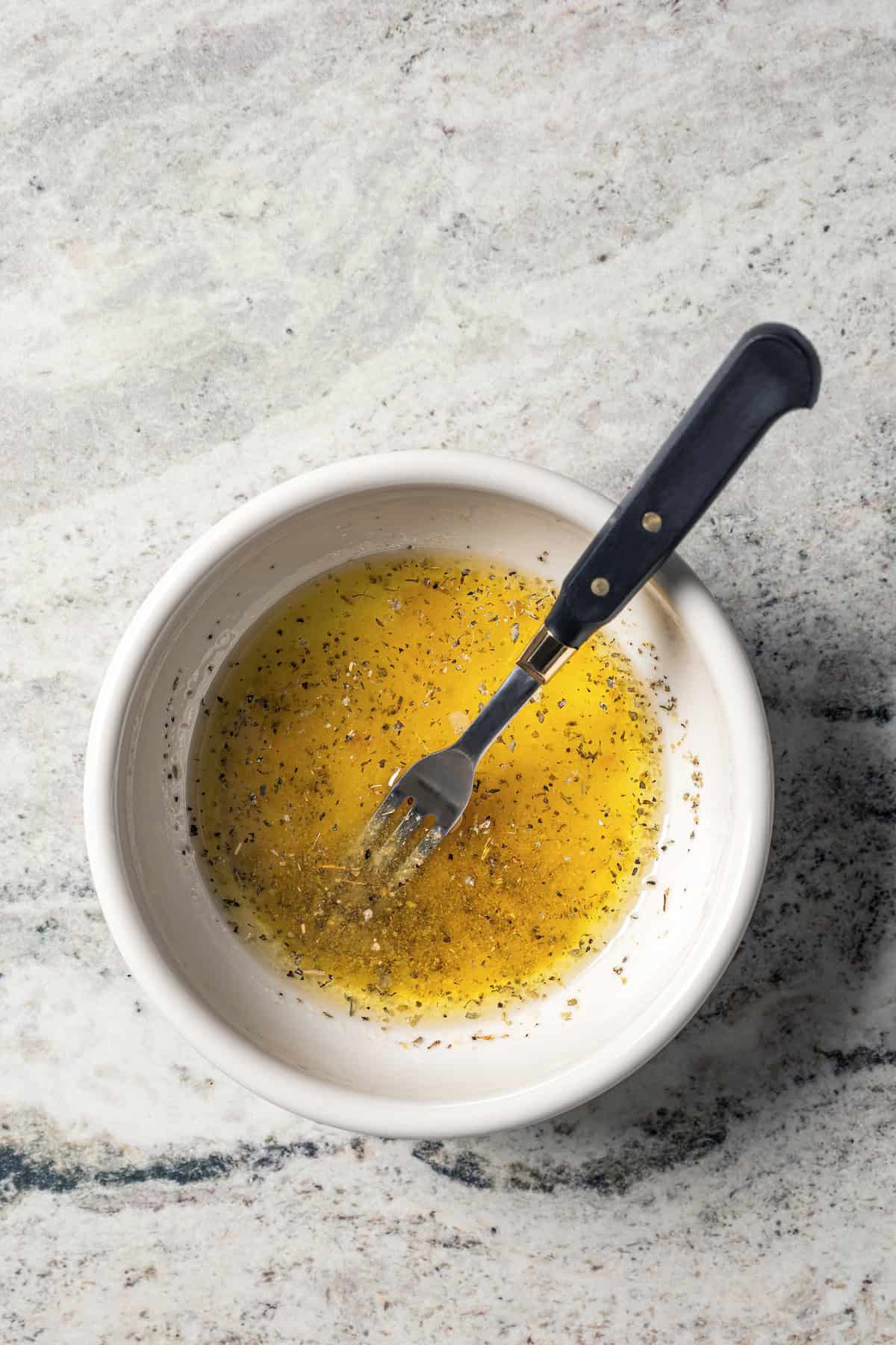 Salad dressing combined in a bowl with a fork.