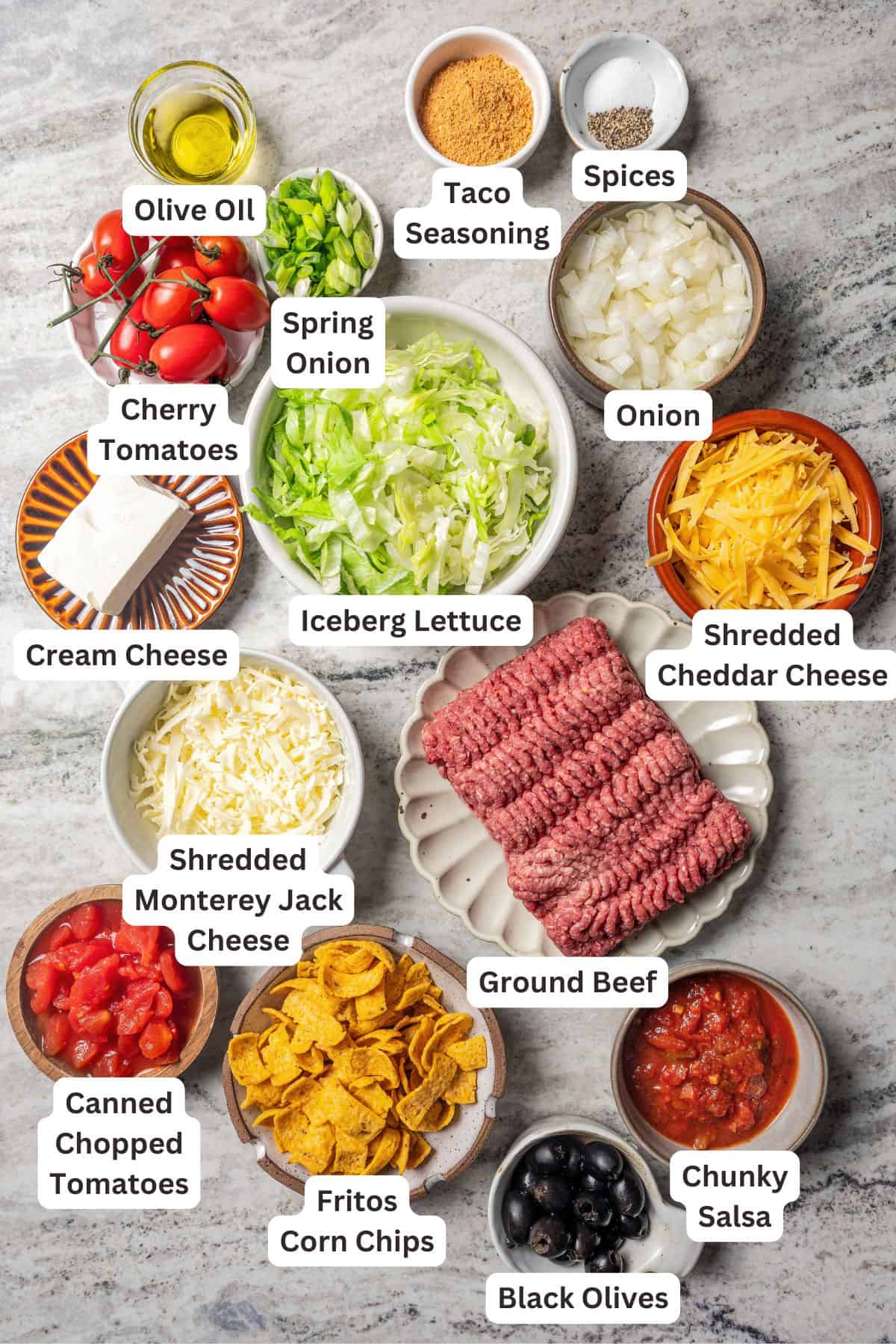 Walking taco casserole ingredients with text labels overlaying each ingredient.