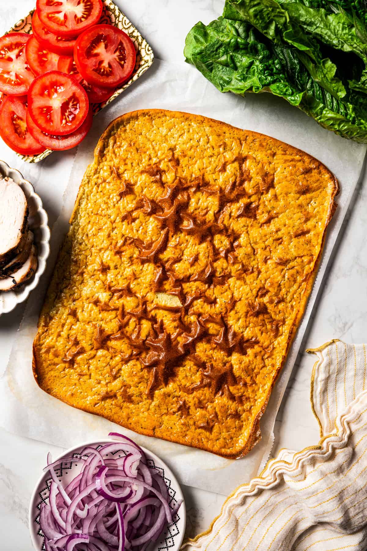 Overhead view of a cottage cheese flatbread surrounded by wrap ingredients.