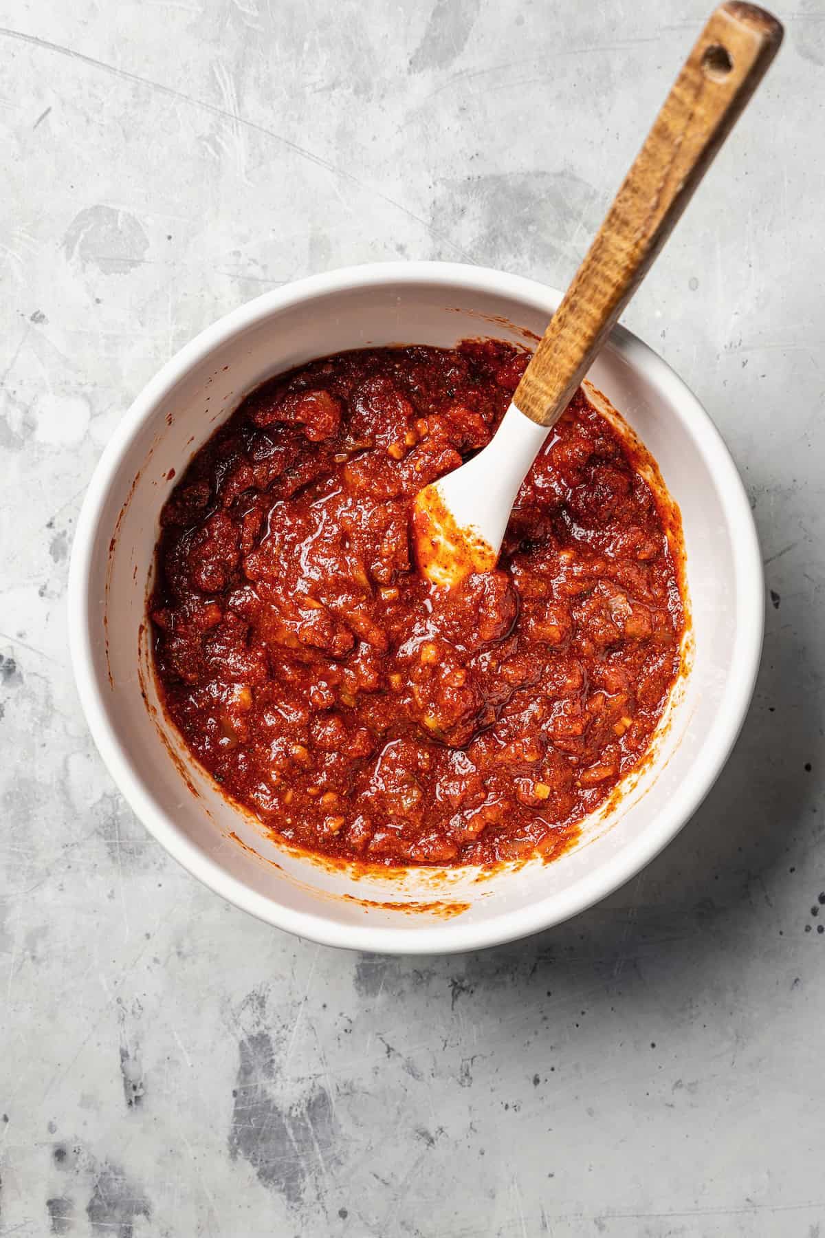 Pulled chicken salsa combined in a bowl with a spoon.