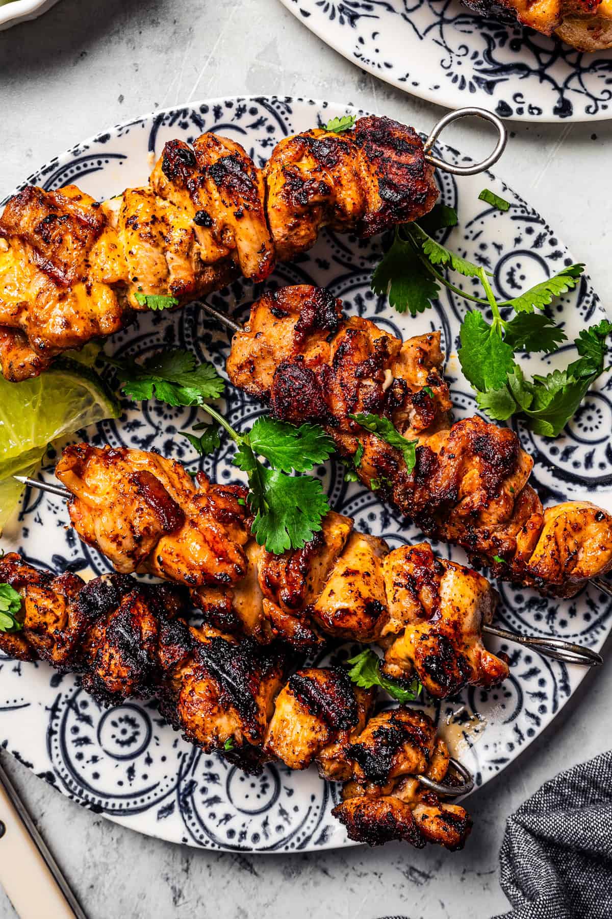 Skewers of bang bang chicken served on a plate.