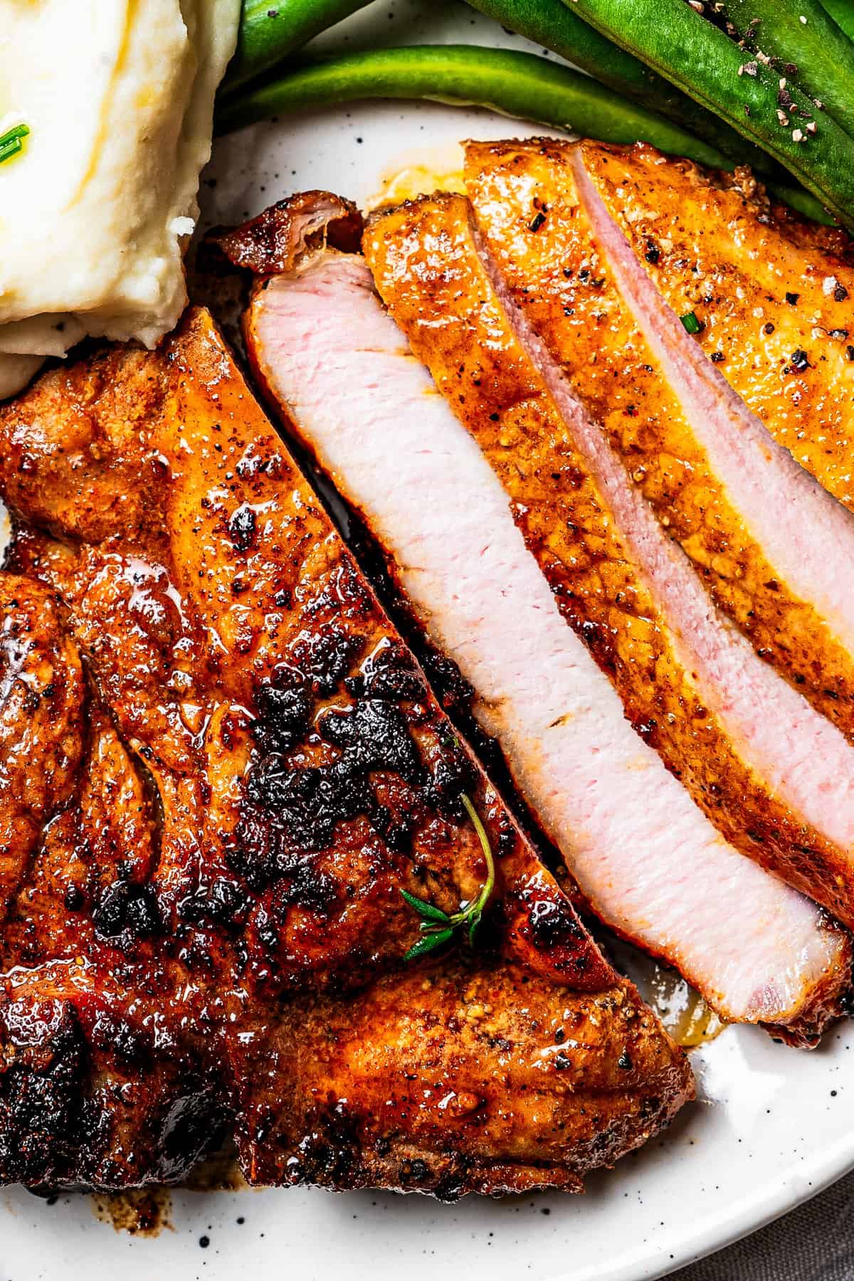 Close up of pork chop cut into slices.