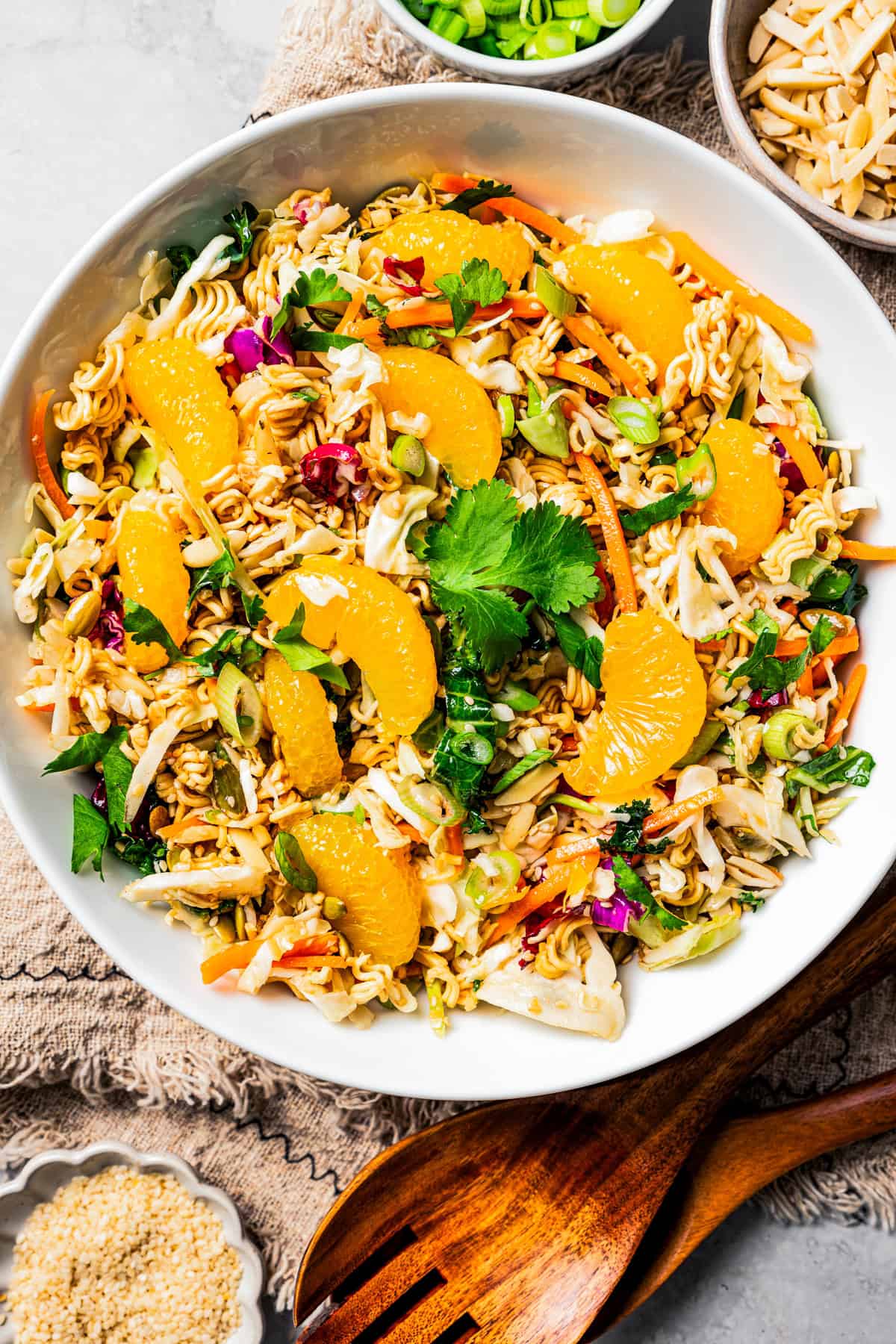 Overhead view of ramen salad in a large bowl garnished with mandarin oranges.