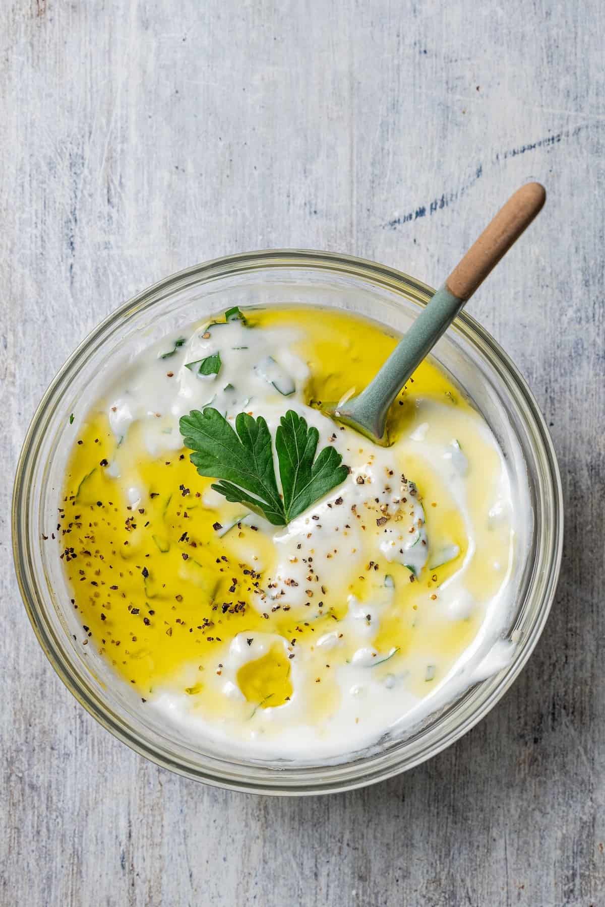 These juicy salmon kabobs with lemon are perfect for grilling! Serve with garlicky yogurt dipping sauce for a delicious and easy summer meal. Garlic sauce ingredients combined in a glass bowl.