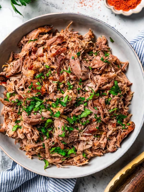 Overhead view of shredded Kalua pork in a large serving bowl.