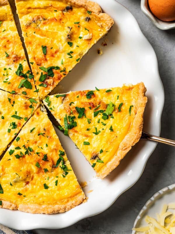 Removing a slice of quiche from a pie plate.
