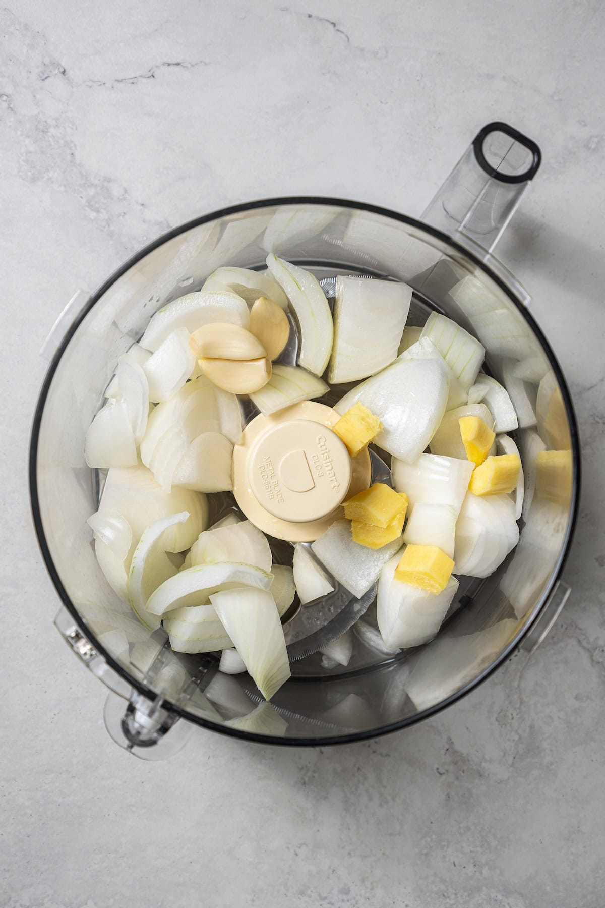 Onion paste ingredients added to a food processor.