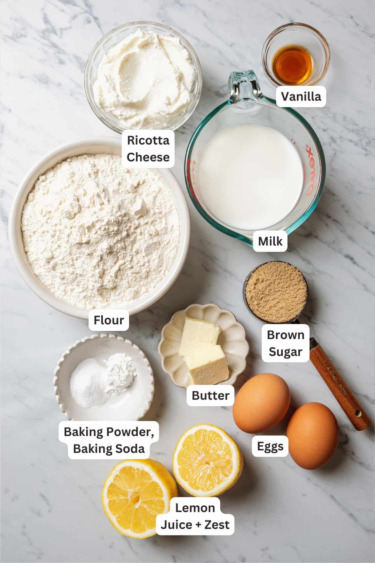 Lemon ricotta pancake ingredients with text labels overlaying each ingredient.