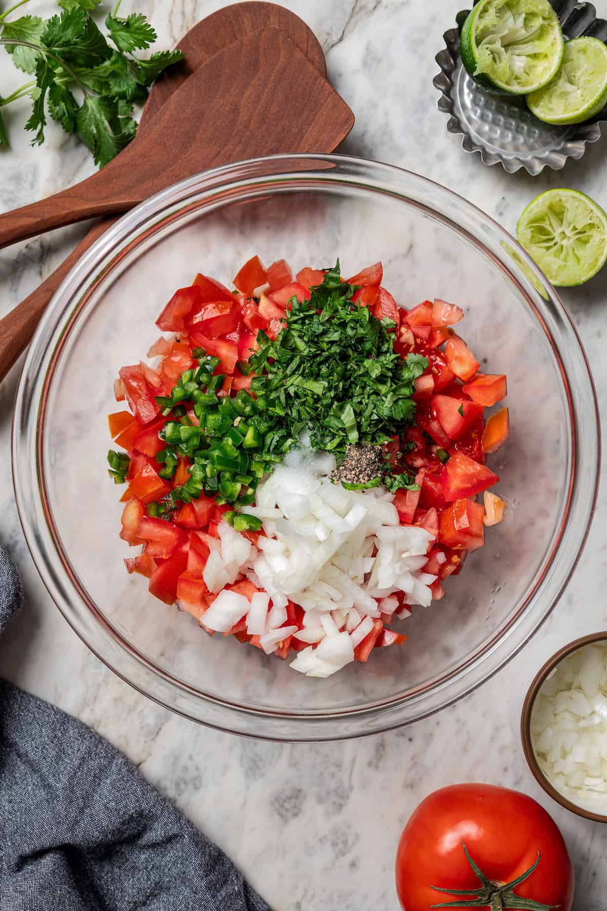 Diced pico de gallo ingredients added to a glass bowl.