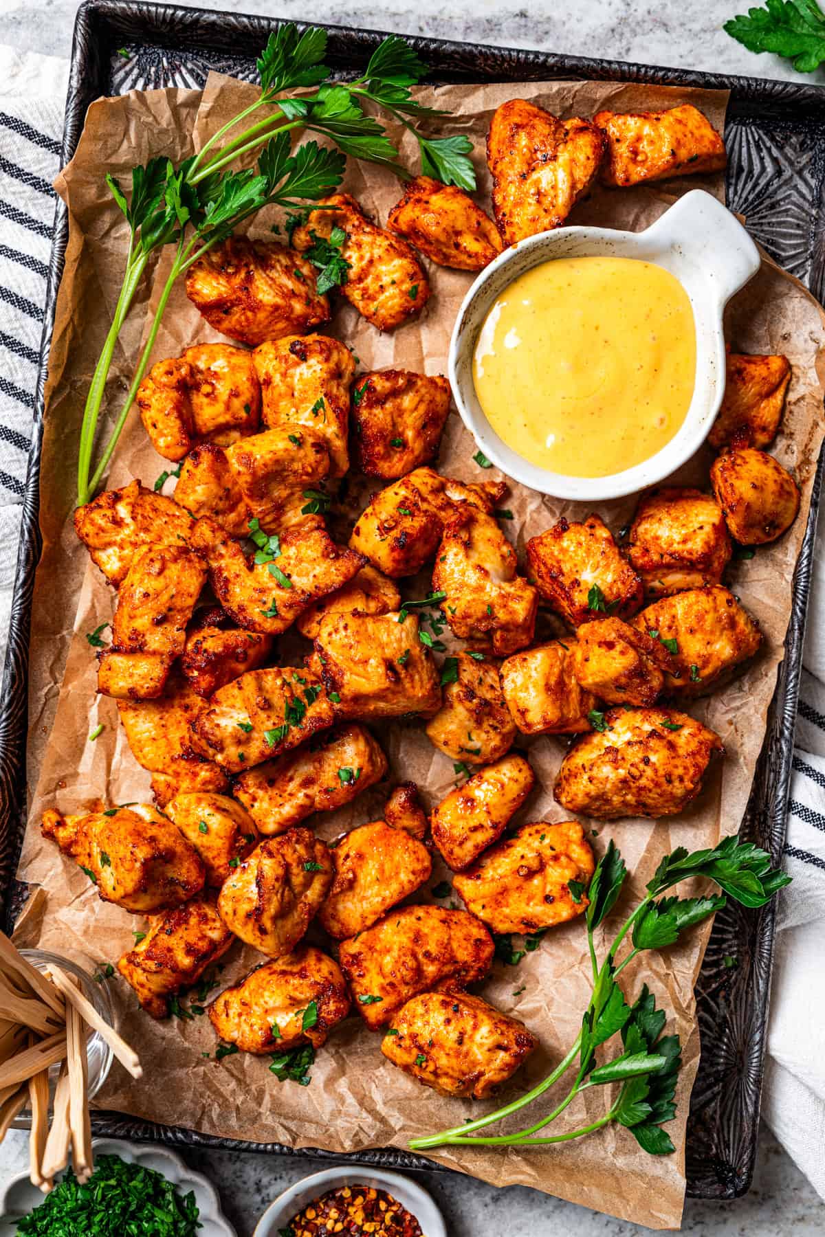 Make crispy air fryer chicken bites in just 15 minutes! Pair these juicy bites with your favorite dipping sauce for an easy meal or appetizer. Air fried chicken bites are served on a tray next to a bowl of honey mustard sauce.