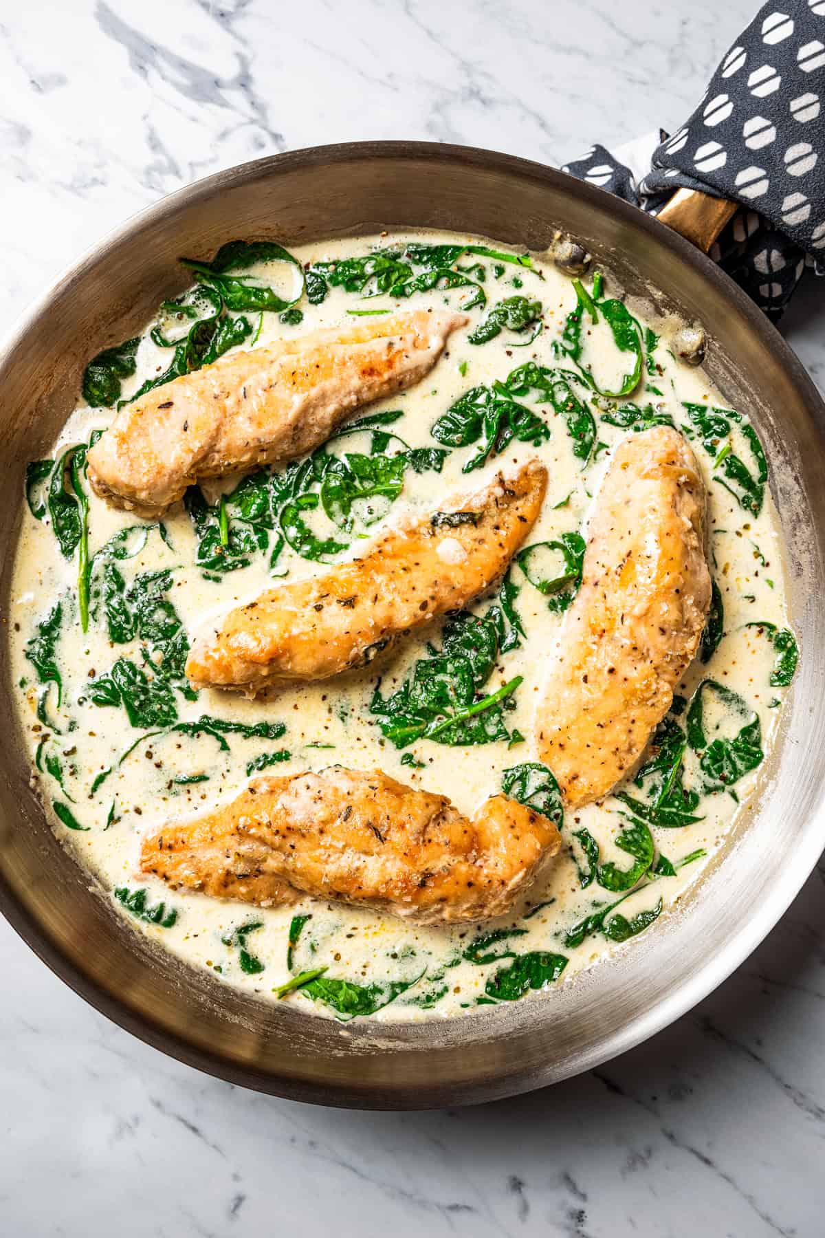 Creamy chicken Florentine is a one-pan dinner with golden-fried chicken smothered in a garlicky spinach cream sauce. Make it in 30 minutes! Chicken tenders in a skillet with creamy sauce and spinach.