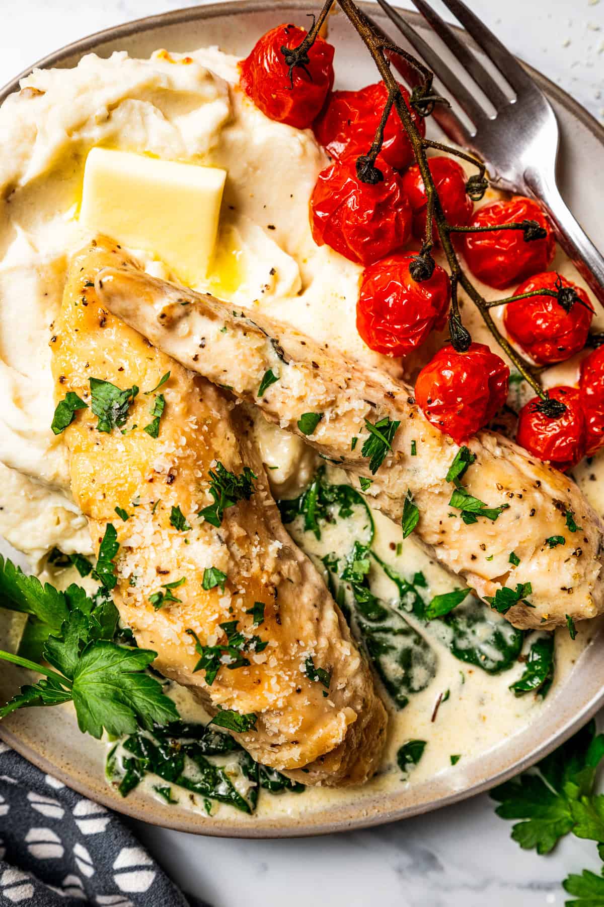 Creamy chicken Florentine is a one-pan dinner with golden-fried chicken smothered in a garlicky spinach cream sauce. Make it in 30 minutes! Florentine chicken served on a dinner plate with mashed potatoes and tomatoes.