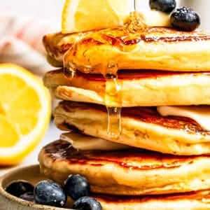 Syrup dripping down a stack of pancakes.