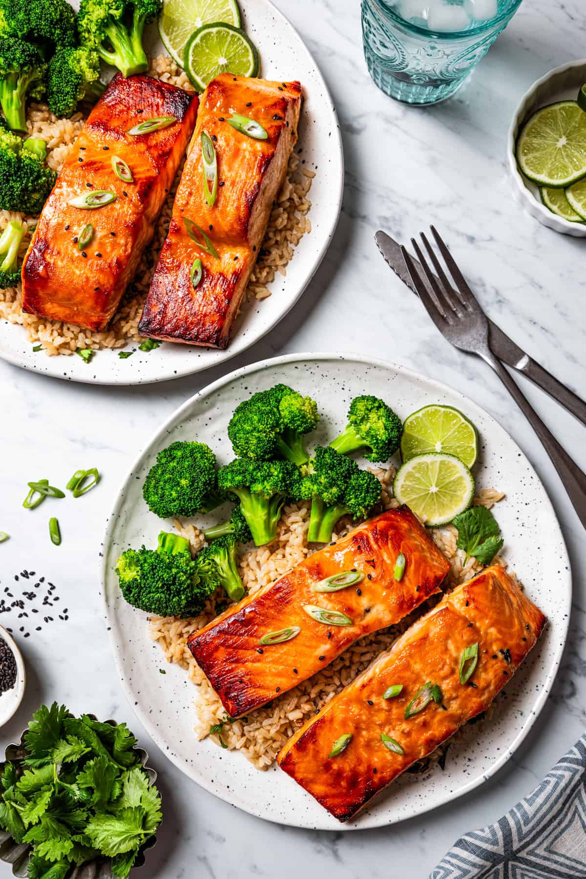 This sweet and savory miso salmon is caramelized outside and tender and flaky inside. Serve it with rice for a quick, easy salmon dinner! Overhead view of two plates with miso salmon fillets served over rice with a side of steamed broccoli.