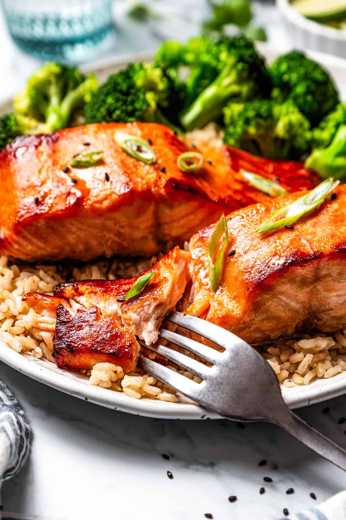 This sweet and savory miso salmon is caramelized outside and tender and flaky inside. Serve it with rice for a quick, easy salmon dinner! A fork flaking a salmon fillet.