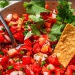 Pico de gallo in a bowl with tomatoes, onion, jalapeño, cilantro, and lime.