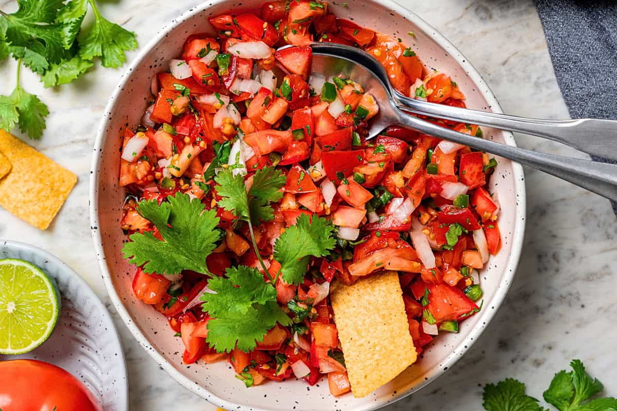 Pico de gallo is a fresh tomato salsa with only 5 ingredients: tomatoes, onion, jalapeño, cilantro, and lime. It’s quick and easy to make! A bowl of homemade pico de gallo.