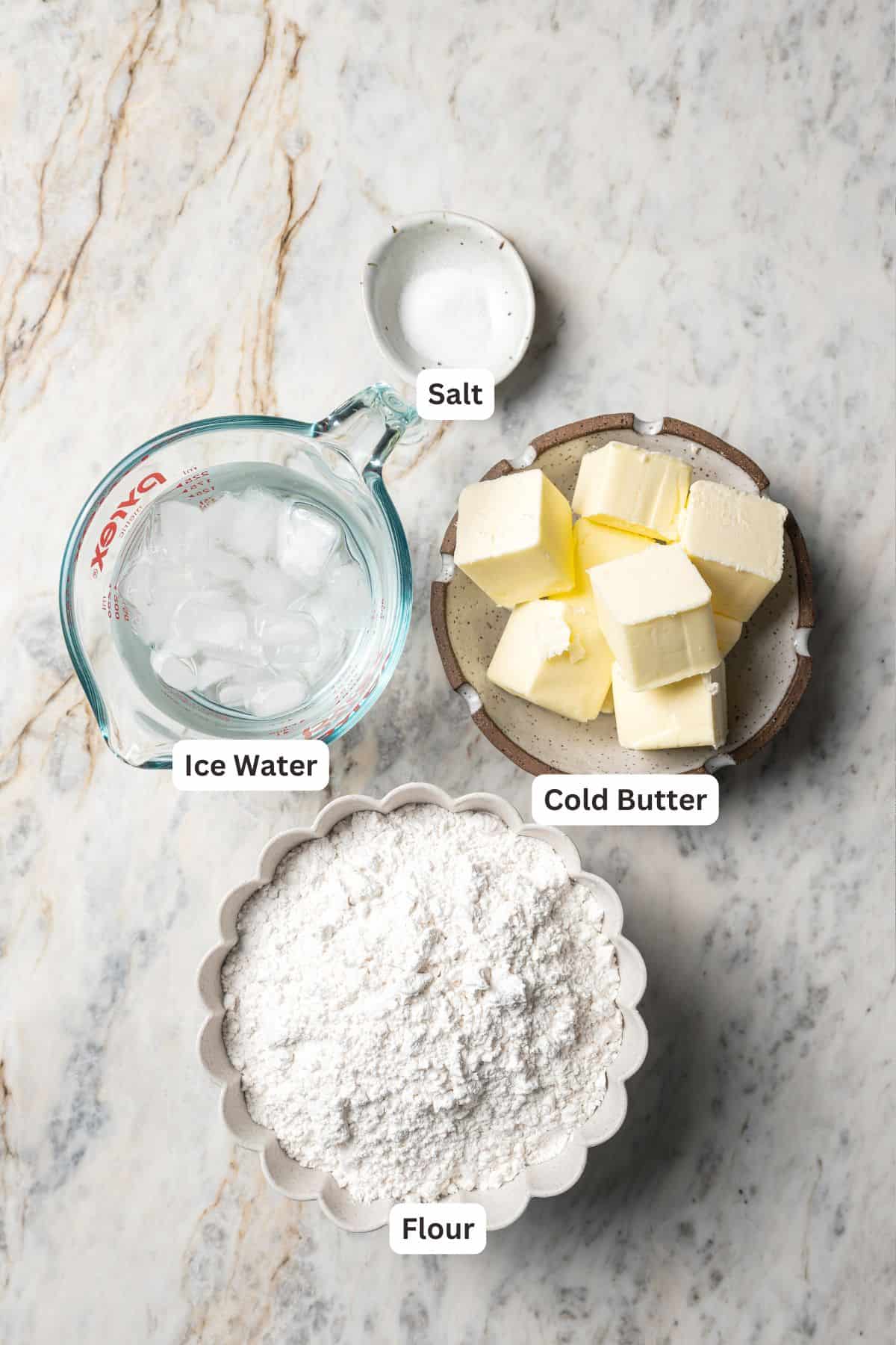 This is the best cherry pie recipe with thick, juicy cherry pie filling flavored with a touch of almond, baked in a buttery, flaky pie crust. Pie dough ingredients with text labels overlaying each ingredient.