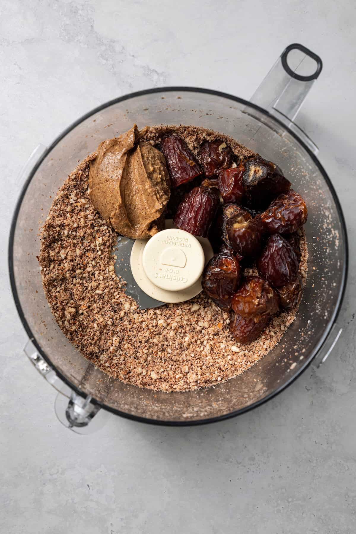 These easy no-bake energy balls are the perfect on-the-go snack packed with juicy dates, raw almonds, chocolate, and nut butter. No oats! Dates and almond butter added to ground almonds and chocolate chips inside a food processor.