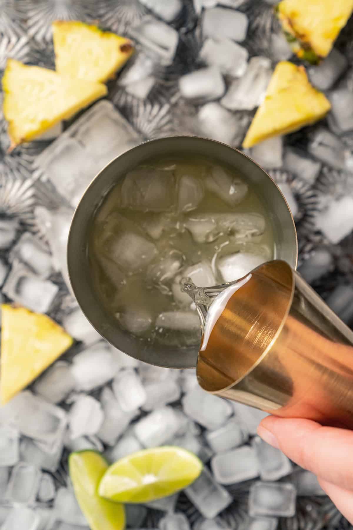 This easy pineapple margarita is a juicy blend of tequila blanco, fresh pineapple juice, and lime, shaken over ice. Don’t forget a salt rim! Adding a shot of Cointreau to a cocktail shaker with ice.