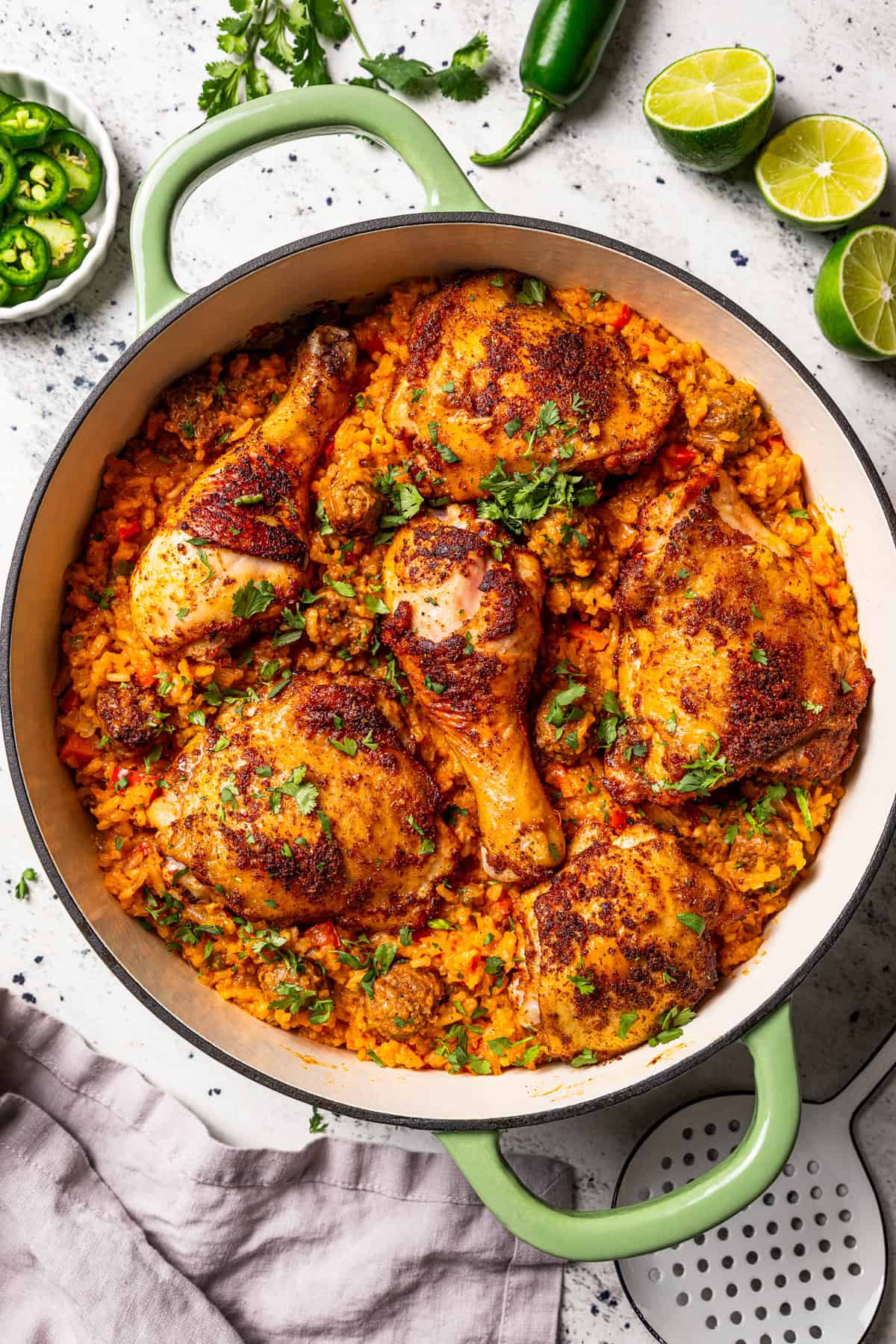 Classic arroz con pollo is a Latin favorite with juicy, seasoned chicken and rice brimming with smoky, savory flavor. Make it in one pot! Overhead view of a large pot of arroz con pollo.