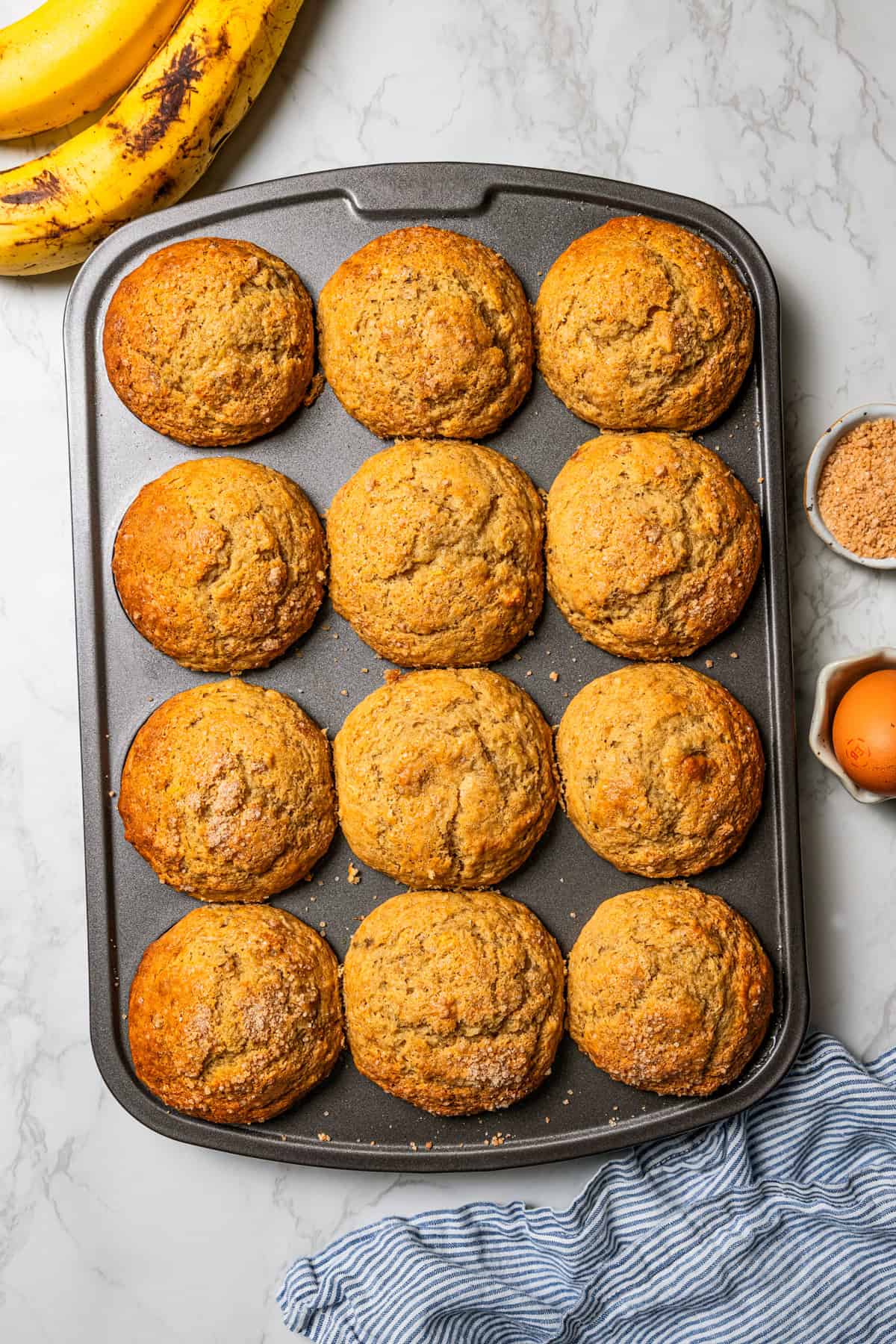 These soft, buttery banana bread muffins are easy to make with maple syrup, brown sugar, and cinnamon. It's impossible to eat just one! Muffins in a pan.