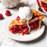 A slice of cherry pie served a la mode with a scoop of ice cream.