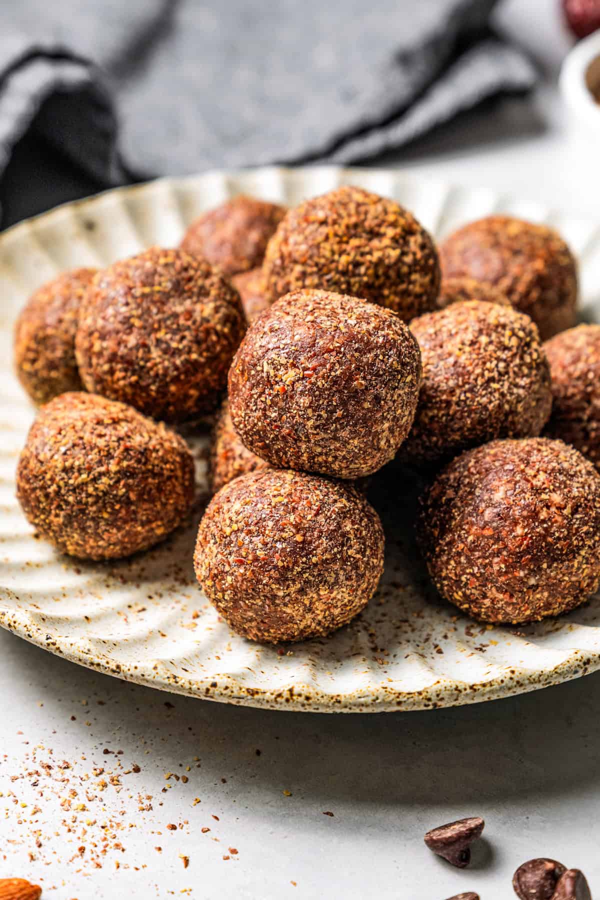 These easy no-bake energy balls are the perfect on-the-go snack packed with juicy dates, raw almonds, chocolate, and nut butter. No oats! Energy balls piled on a plate.