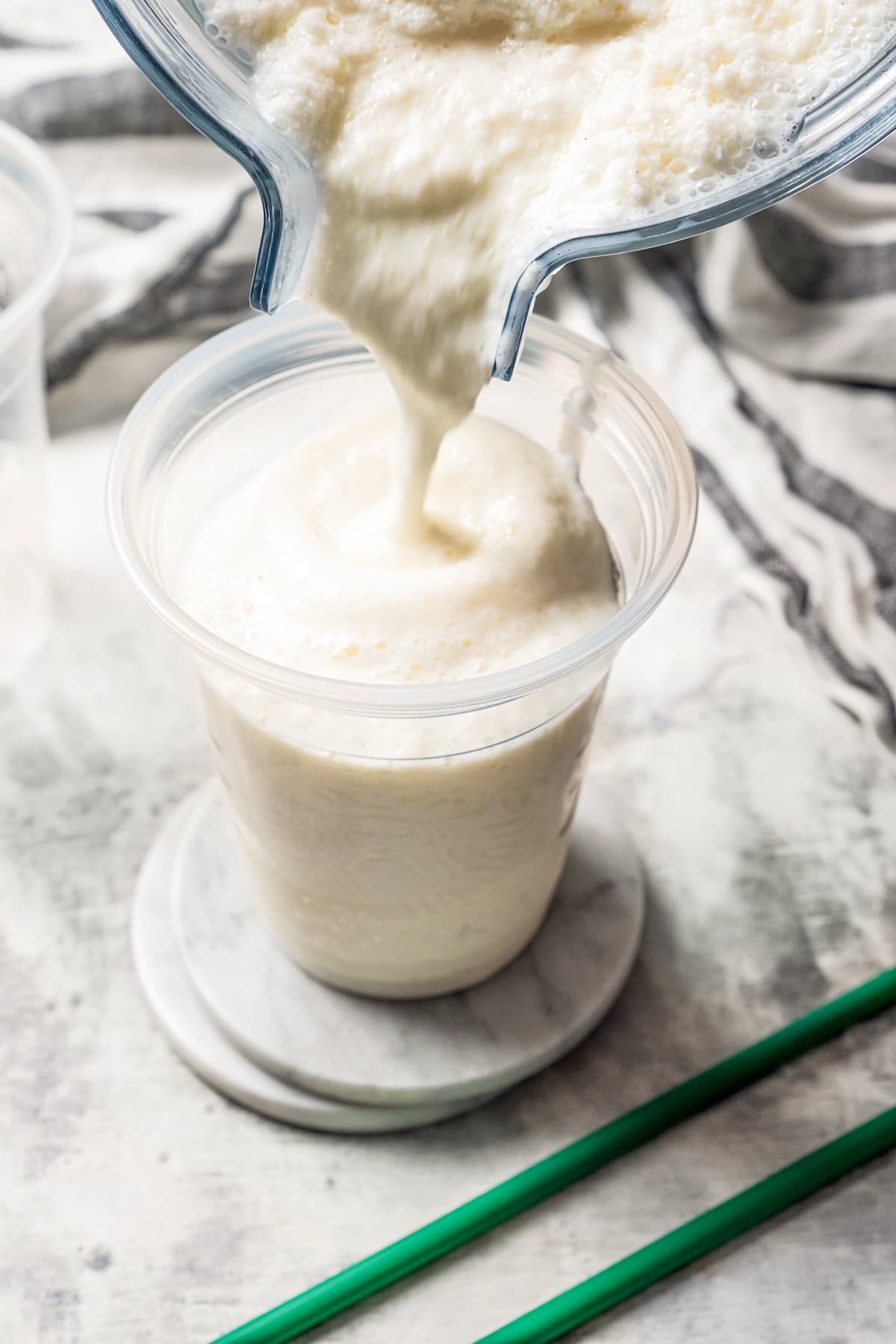 Pouring a vanilla frappuccino from the blender into a Starbucks-style cup.