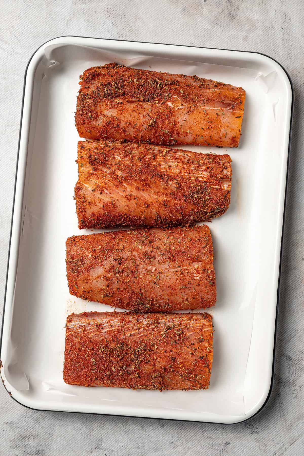 Blackened mahi mahi is a quick fish dish packed with Southern flavor thanks to a spicy homemade Cajun seasoning rub. Great for weeknights! Blackened mahi mahi filets on a baking tray.