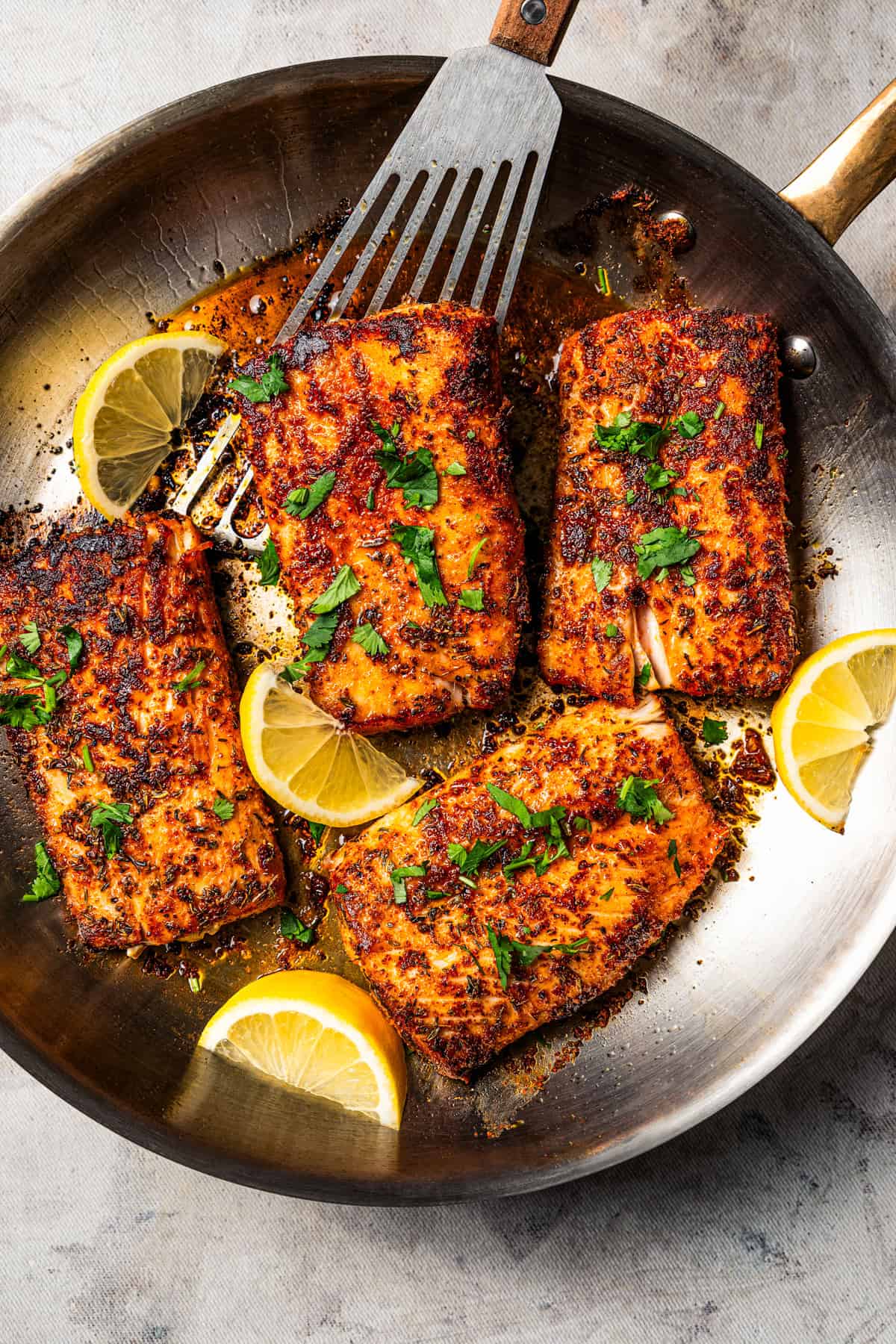 Blackened mahi mahi is a quick fish dish packed with Southern flavor thanks to a spicy homemade Cajun seasoning rub. Great for weeknights! Mahi mahi in a skillet garnished with fresh herbs and lemon wedges.