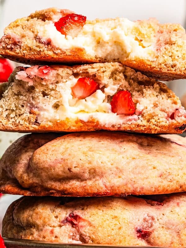 Four strawberry cheesecake cookies are stacked on a plate, with a bite missing from the top two cookies. Recipe and photo by diethood.com