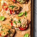 Overhead view of baked stuffed chicken breasts on a parchment-lined baking sheet. Photo by diethood.com