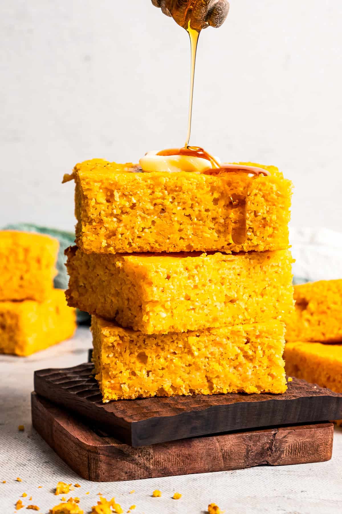 This sweet potato cornbread is completely delicious and easy to make! It’s moist, flavorful, with a touch of sweetness and tangy buttermilk. Drizzling honey over a stack of sweet potato cornbread slices.