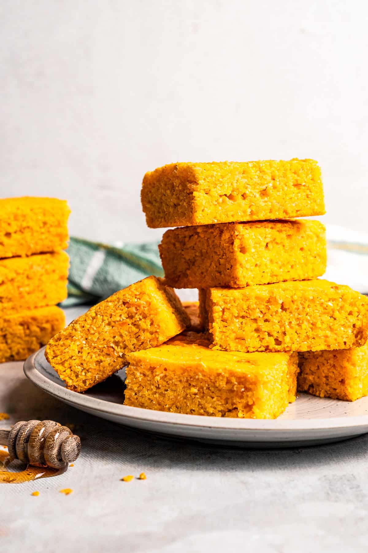 Slices of cornbread stacked up on a plate.