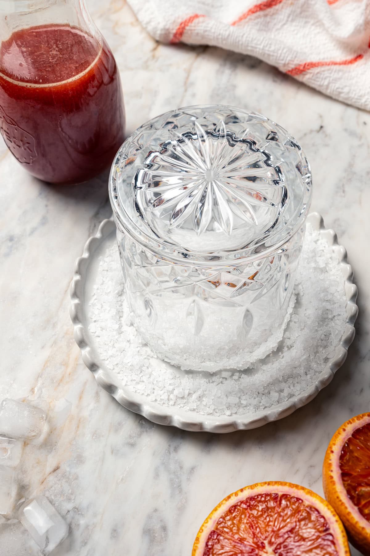 A glass turned upside down in a shallow plate of salt to make a salt rim.