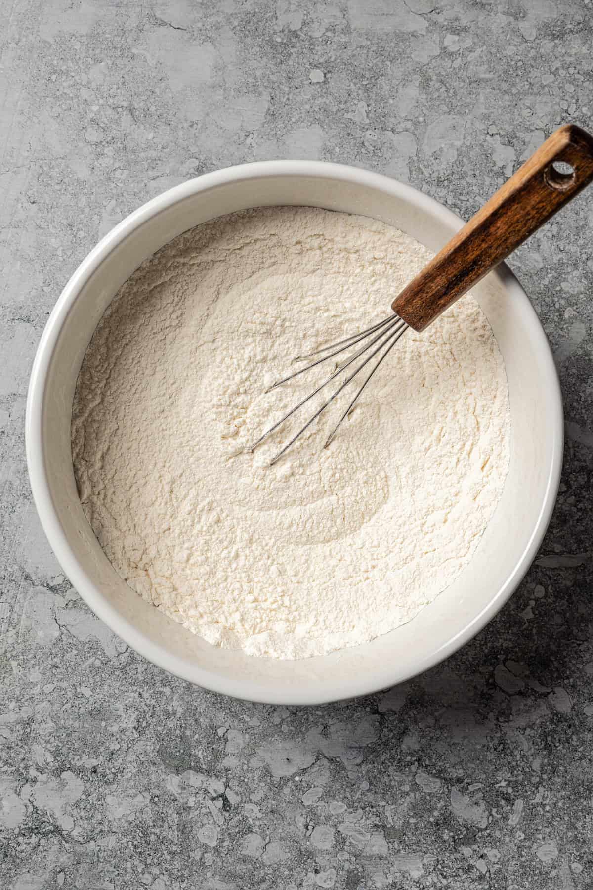 Dry ingredients combined in a bowl with a whisk.