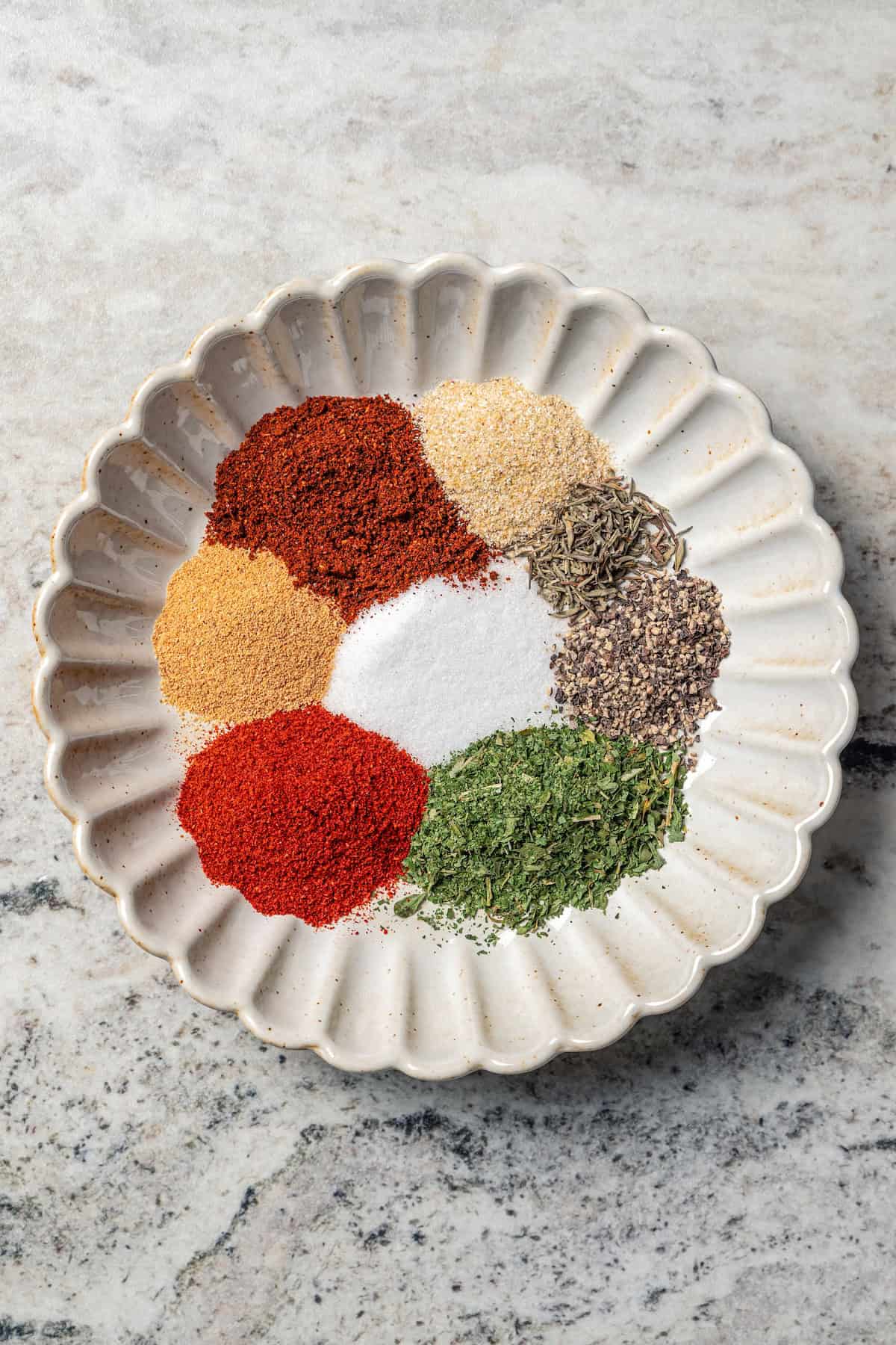 Burger spices and herbs combined in a scalloped bowl.