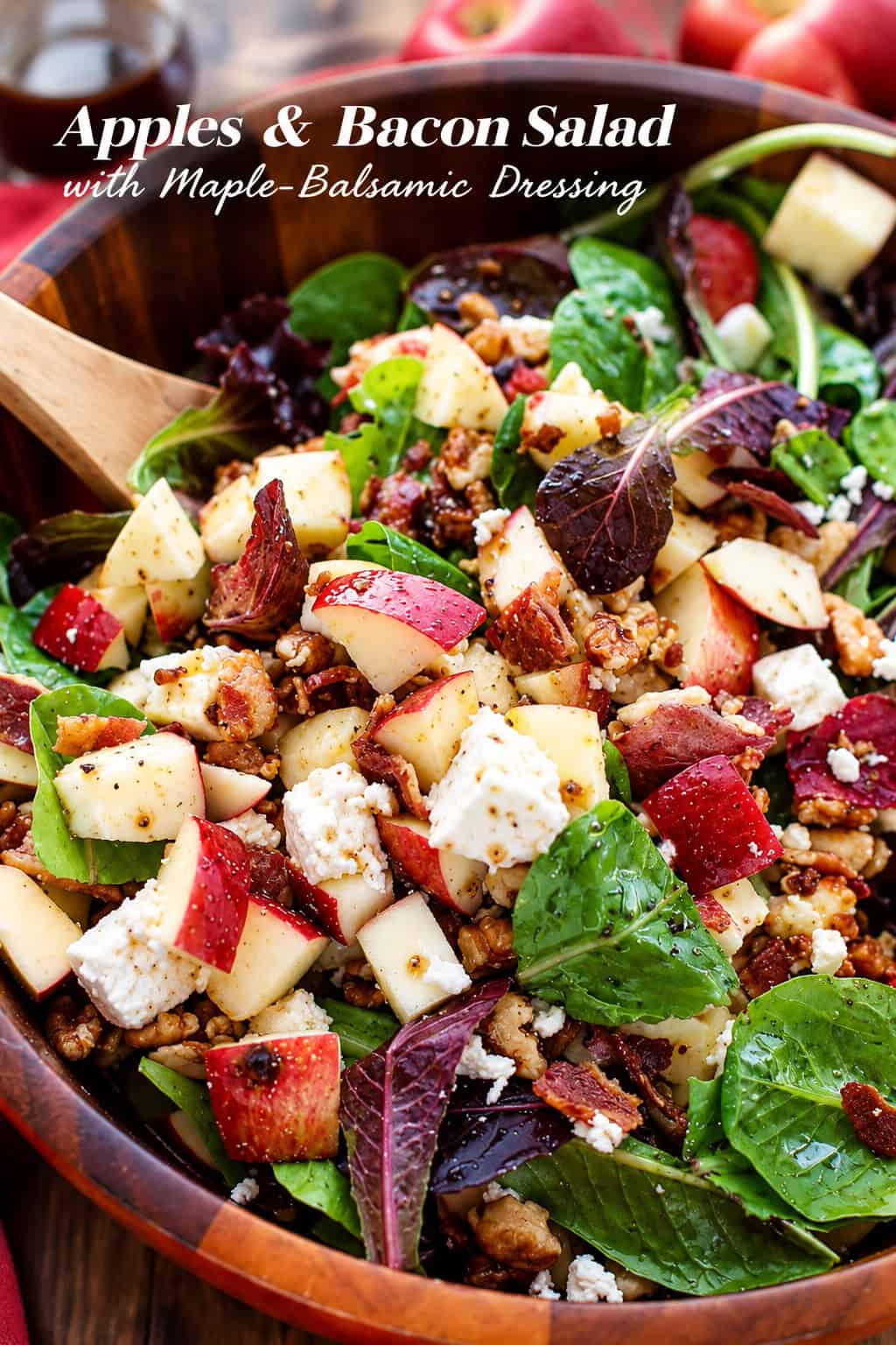 This apple salad recipe combines crisp fall apples tossed with smoky bacon, crunchy walnuts, and creamy feta in a sweet-tangy maple dressing. Apple bacon salad with mixed greens, crisp apples, bacon, feta cheese, and walnuts in a wooden bowl.